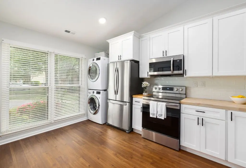 Modern Lubbock kitchen and laundry area with a refrigerator, range, microwave, washer, and dryer