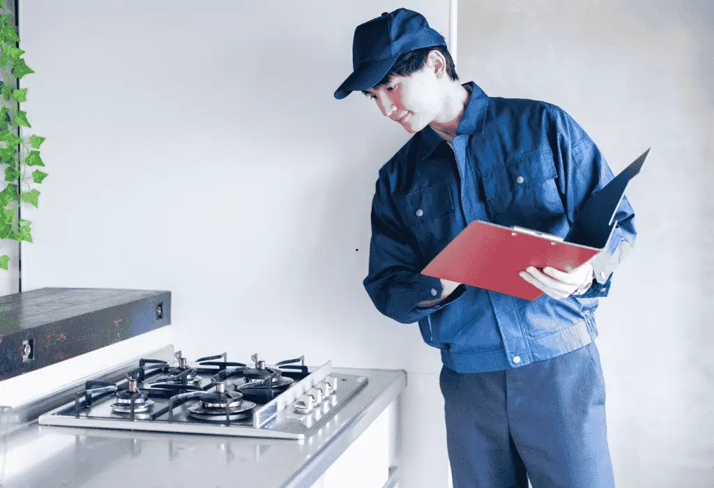 Appliance technician checking a gas cooktop